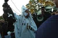 Un manifestante vestido con el traje del Ku Klux Klan ahorca animales de peluche frente a la corte del poblado de Jena