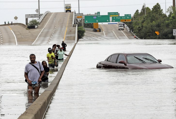 Evacuados por los efectos de la tormenta Harvey recorren una inundada Interestatal 610