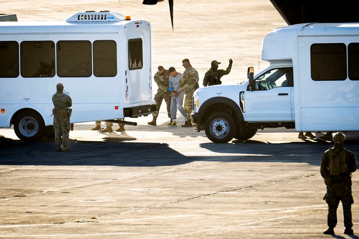 Miembros del ej�rcito escoltan a migrantes indocumentados, incluyendo algunos con antecedentes penales, al bajar de un avi�n militar C-130 que acababa de aterrizar en la base naval estadounidense de la Bah�a de Guant�namo, Cuba, el viernes 7 de febrero de 2025. (Doug Mills/The New York Times).