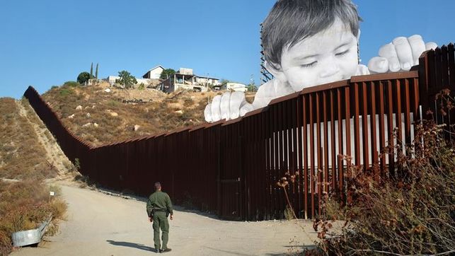 Un artista francés levanta a un niño gigante entre la frontera de EE.UU. y México
