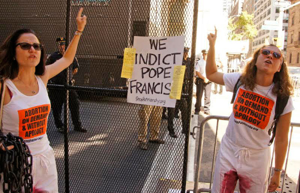 Posting People's Indictment Against Pope Francis and the Catholic Church on police fence outside St. Patrick's Cathedral 