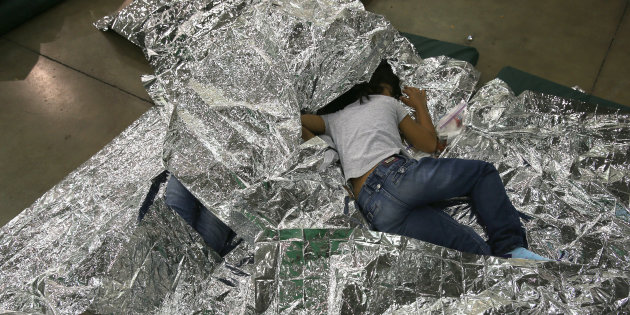 Una niña centroamericana descansa sobre mantas térmicas en un centro de detención dirigido por la Patrulla Fronteriza de los Estados Unidos.