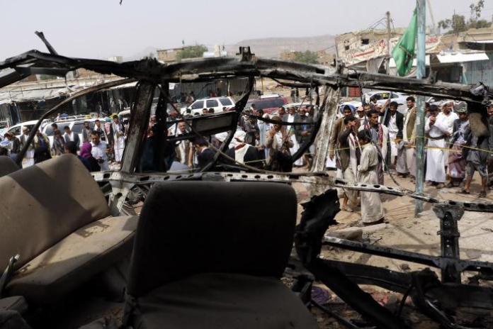 Se ve a personas cerca de un autobús destruido por un ataque aéreo que mató a decenas de niños, en una fotografía tomada el 12 de agosto de 2018 en Saada, Yemen.