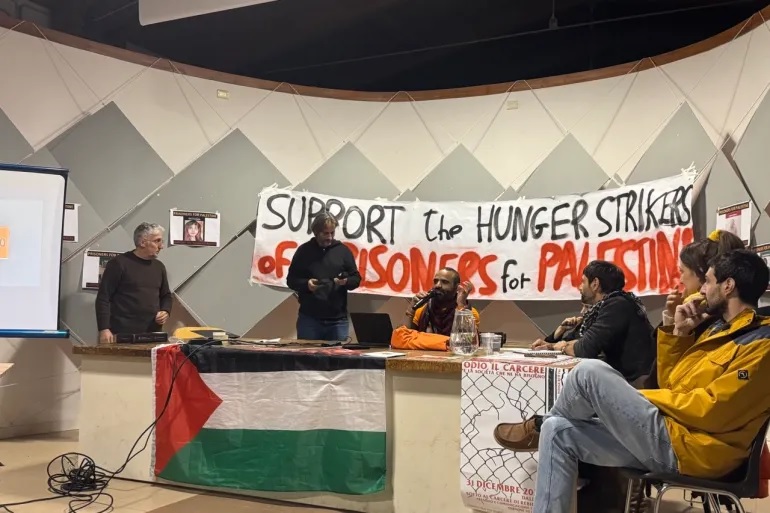 A table with speakers at an event in support of Pal Action hunger strikers